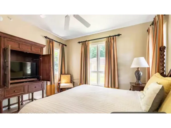 a bedroom with a bed and a flat tv screen on dresser
