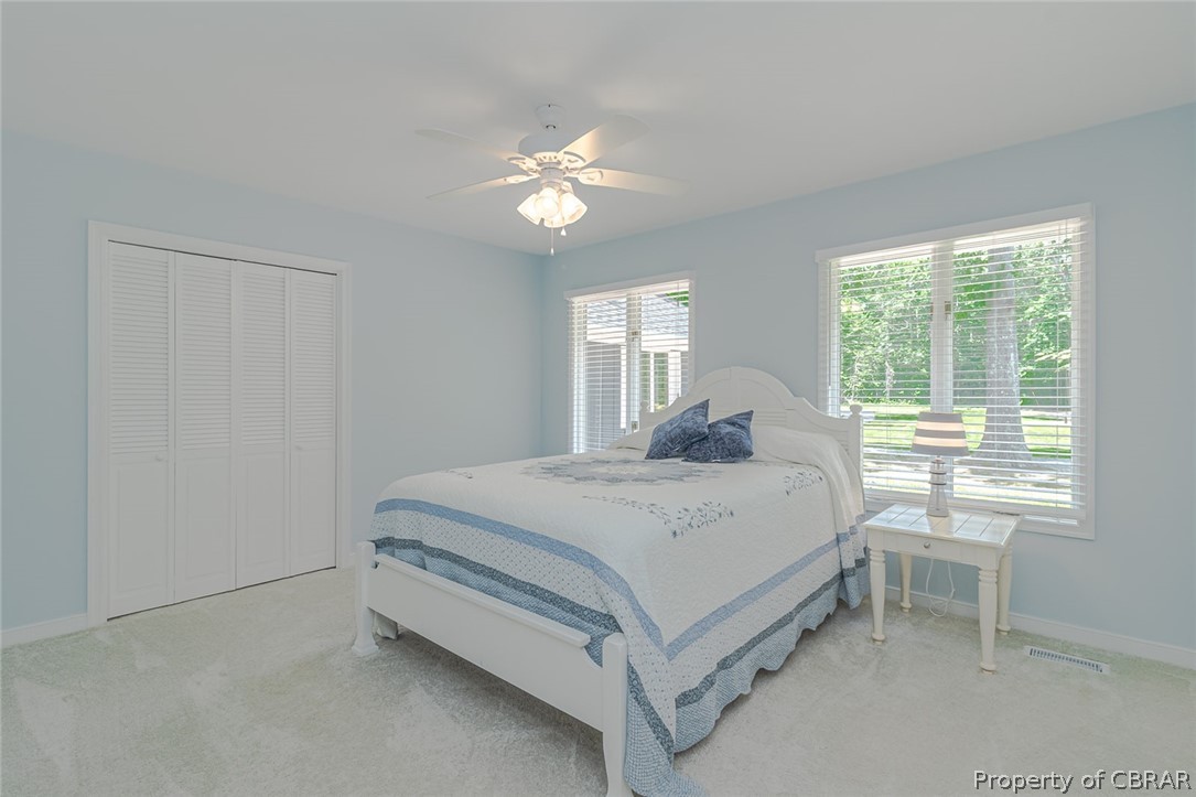 988 Queenstown Road Lancaster, VA 22503 - Photo 22 of 37 a spacious bedroom with a bed and a table in it