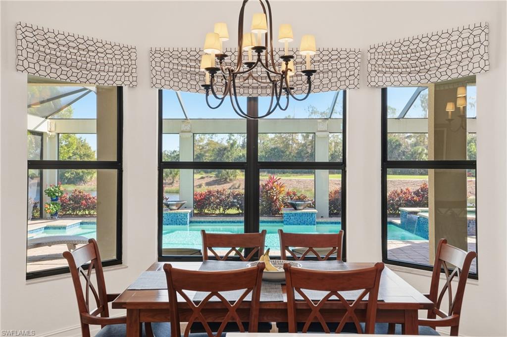 9923 Corso Bello Drive Naples, FL 34113 - Photo 18 of 47 a view of a dining room with furniture large windows and wooden floor