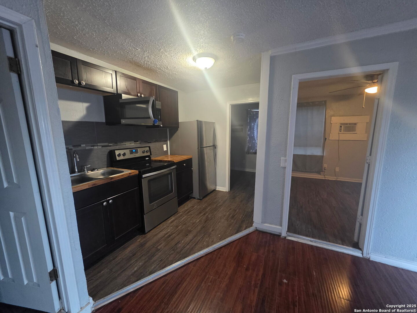 1431 Cantrell Drive, Unit 4 San Antonio, TX 78221 - Photo 4 of 5 a kitchen with stainless steel appliances granite countertop a refrigerator a sink a stove and wooden floor