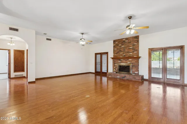 a view of empty room with wooden floor and fireplace