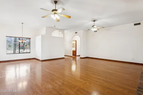 a view of an empty room with a window and wooden floor