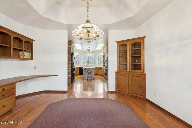 an empty room with windows and chandelier fan