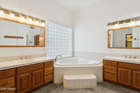 a bathroom with a tub sink and mirror