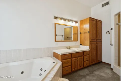 a bathroom with a granite countertop bathtub shower sink mirror and toilet