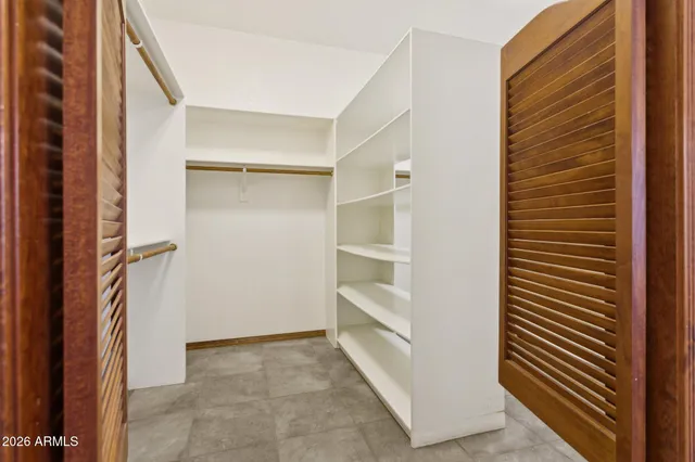 an empty room with windows and ceiling fan