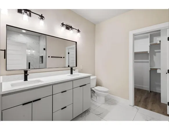 a bathroom with a toilet a sink a mirror and a shower