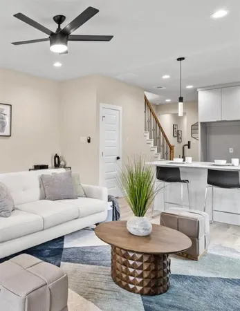 a living room with furniture potted plant and kitchen view