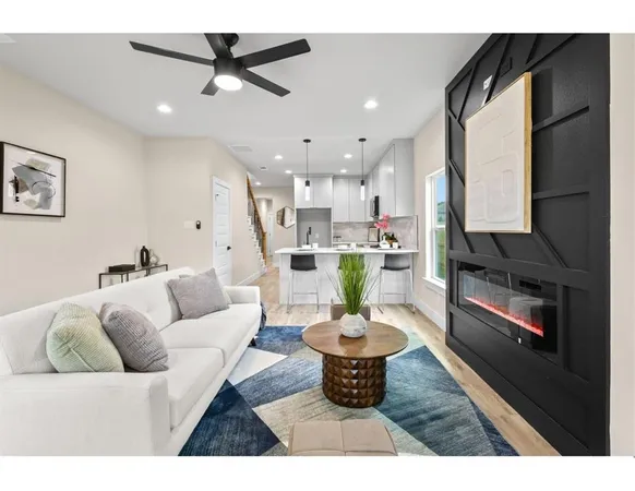 a living room with furniture a dining table and a kitchen view