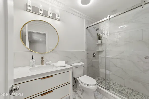 a bathroom with a toilet sink vanity granite and a mirror