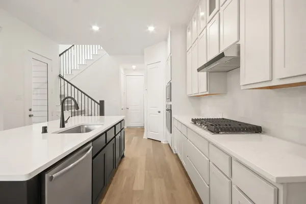 a kitchen with a sink a stove and cabinets