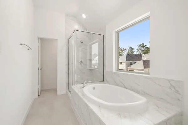 a spacious bathroom with a tub a sink and mirror