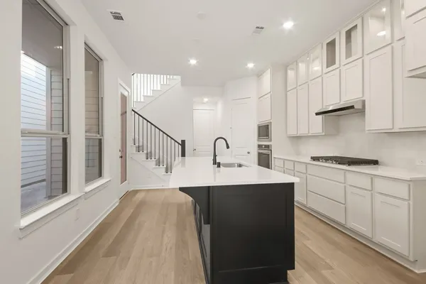 a kitchen with a sink stove and cabinets