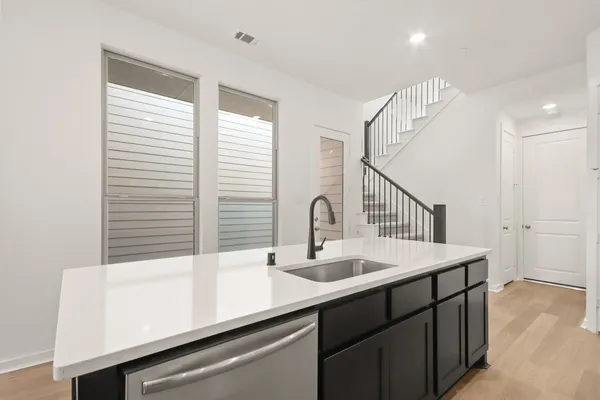 a kitchen with stainless steel appliances a sink a stove a refrigerator and cabinets