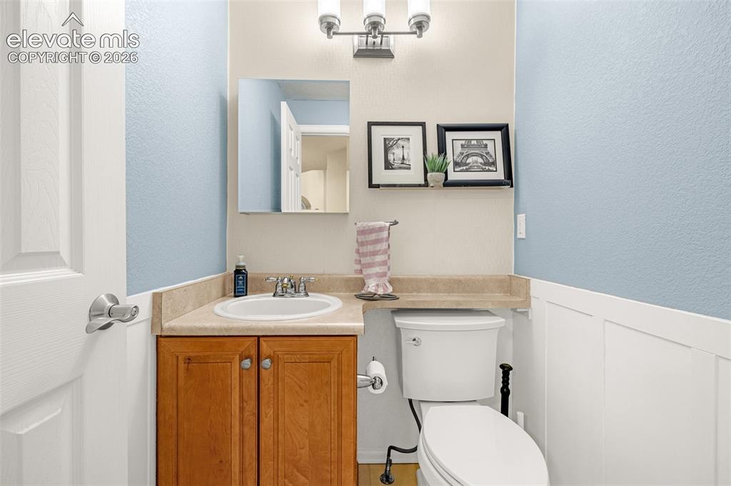 9127 Oakmont Road Peyton, CO 80831 - Photo 15 of 49 a bathroom with a granite countertop toilet sink and mirror