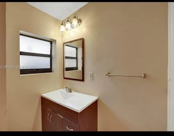 a bathroom with a sink mirror and vanity