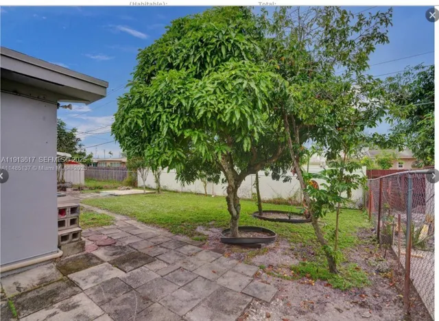 a view of a backyard with large trees and plants