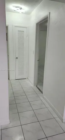 a view of a livingroom with an empty space and a hallway