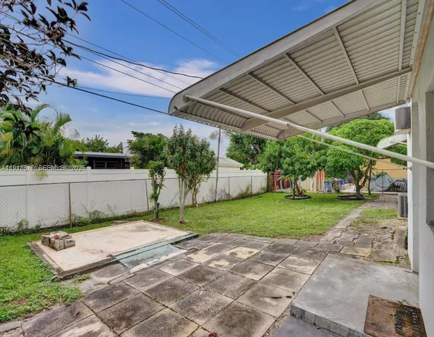 a view of a backyard with table and chairs under an umbrella