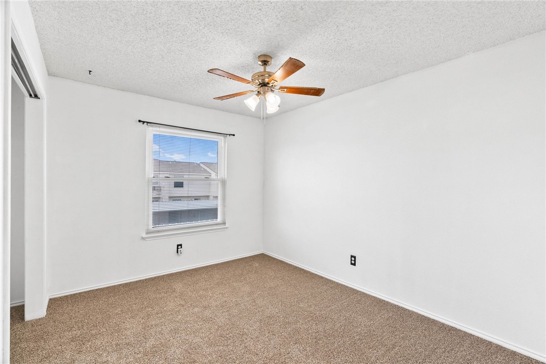 6702 Everhart Road, Unit G105 Corpus Christi, TX 78413 - Photo 11 of 17 an empty room with a window and a ceiling fan
