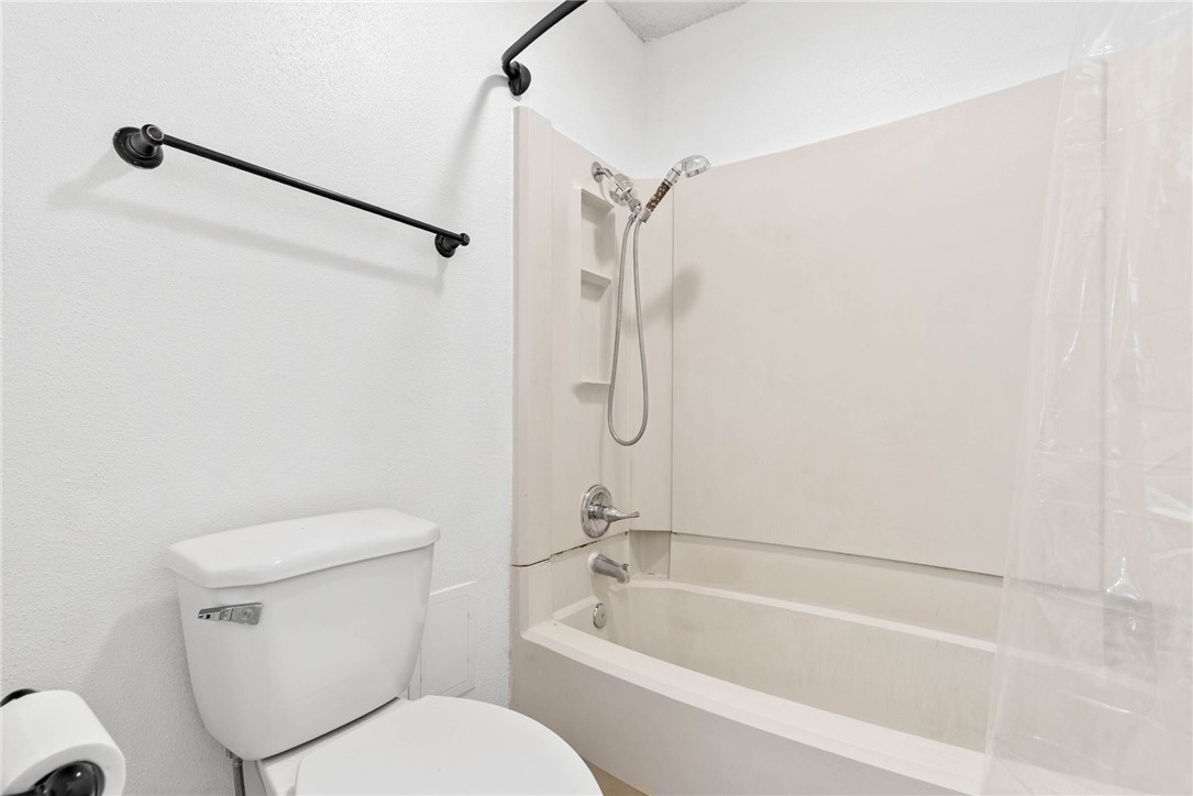 6702 Everhart Road, Unit G105 Corpus Christi, TX 78413 - Photo 13 of 17 a bathroom with a toilet and a bath tub