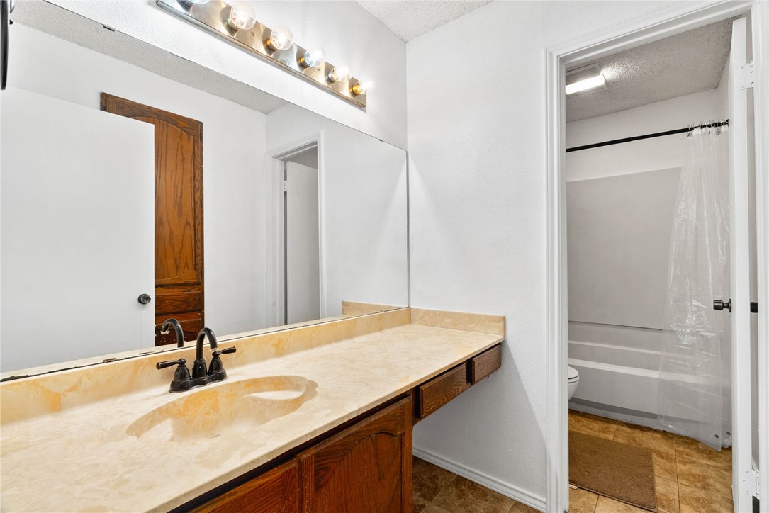 6702 Everhart Road, Unit G105 Corpus Christi, TX 78413 - Photo 14 of 17 a bathroom with a granite countertop sink and a mirror