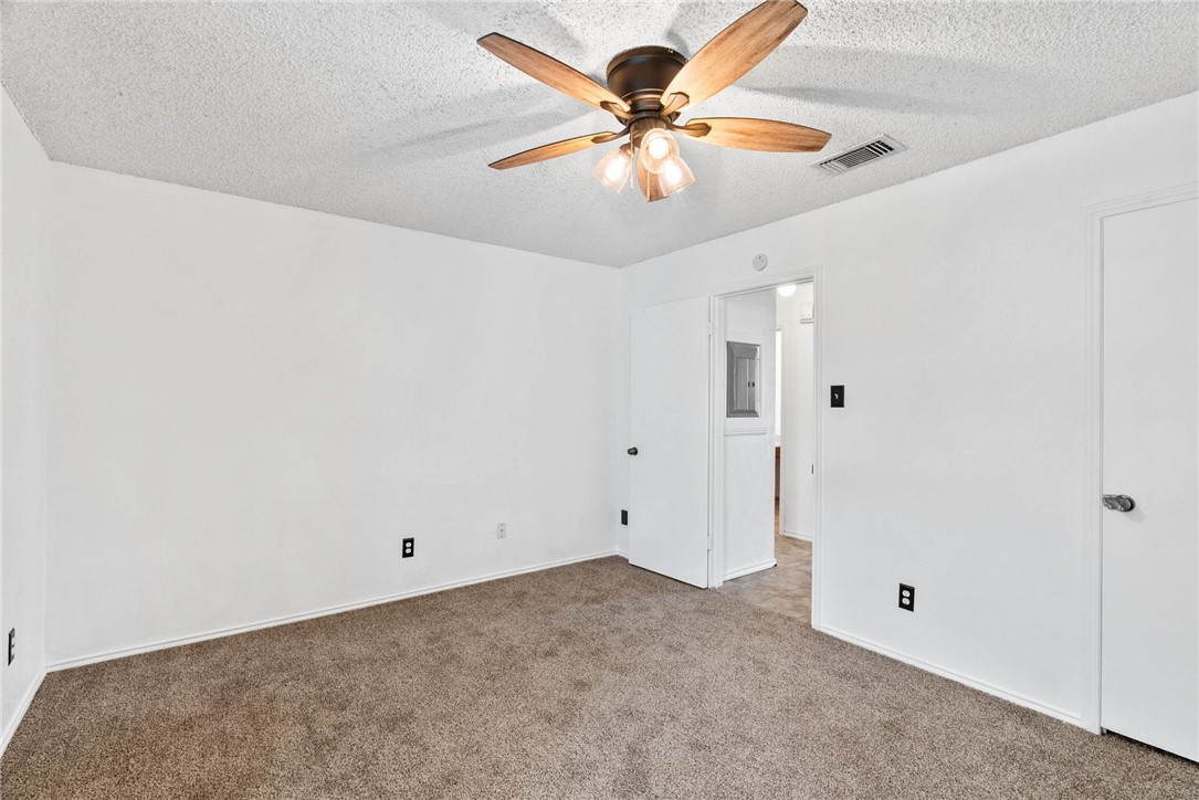 6702 Everhart Road, Unit G105 Corpus Christi, TX 78413 - Photo 9 of 17 an empty room with a chandelier fan and a ceiling fan