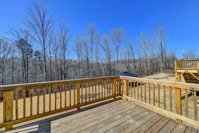 a view of wooden deck and trees with wooden fence