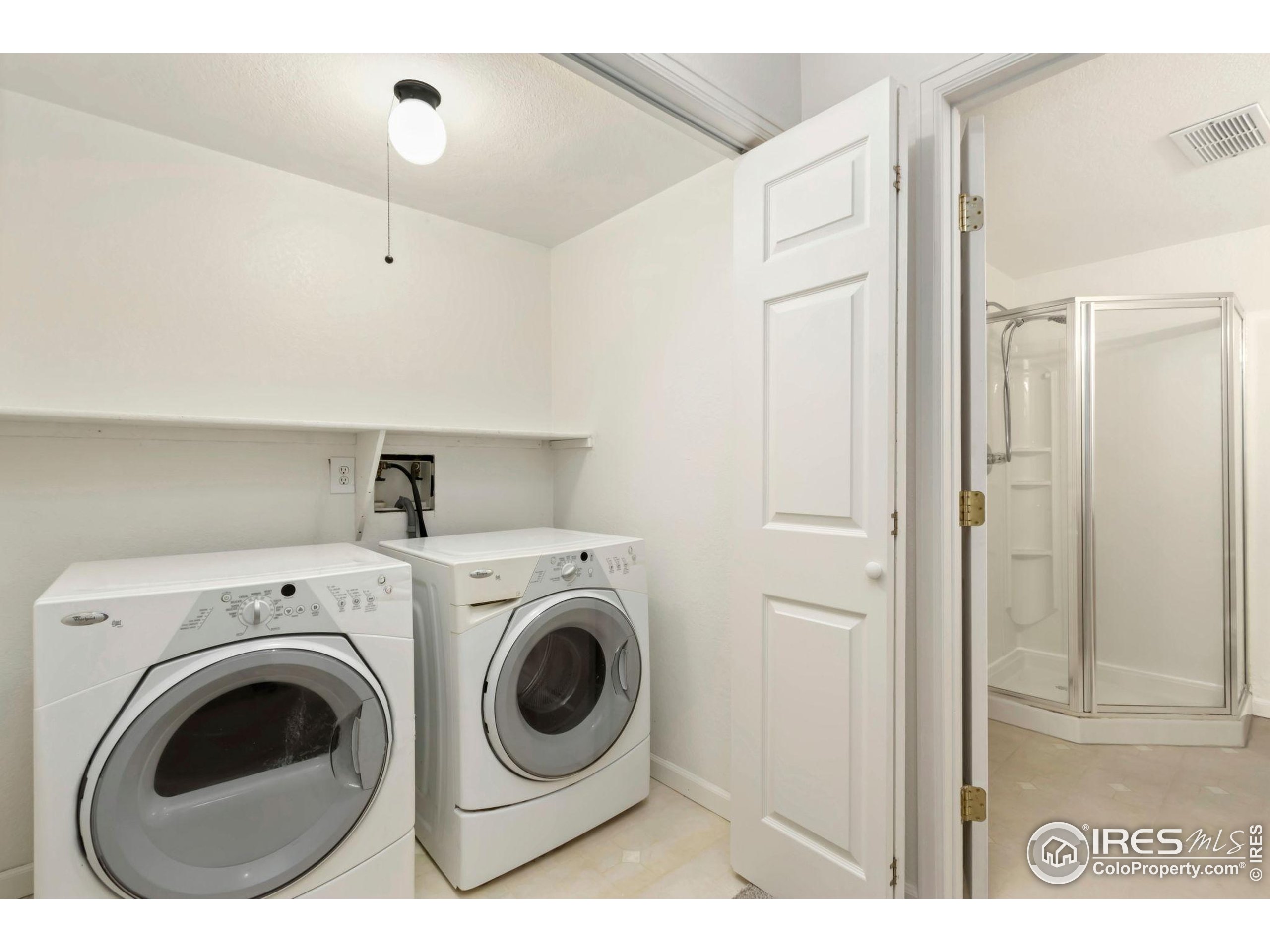 2925 West Stuart Street, Unit 11 Fort Collins, CO 80526 - Photo 25 of 34 a view of washer and dryer with kitchen in the background