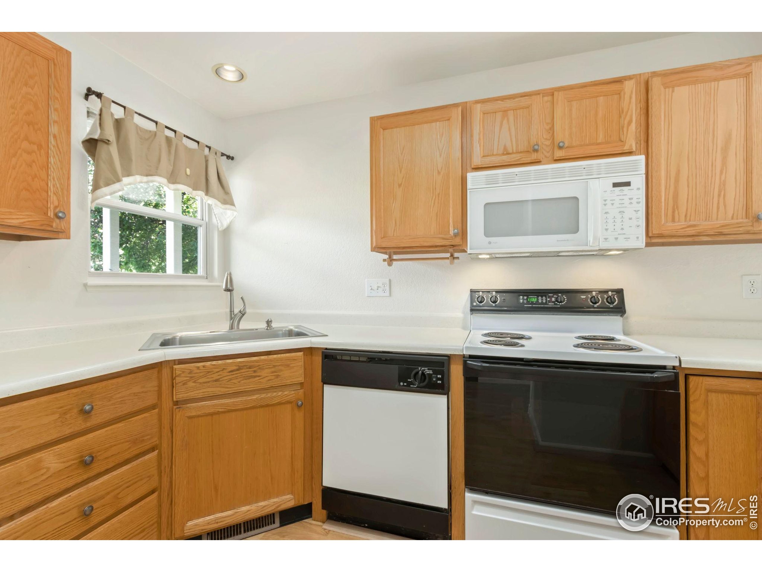 2925 West Stuart Street, Unit 11 Fort Collins, CO 80526 - Photo 4 of 34 a kitchen with stainless steel appliances granite countertop a stove a sink and a microwave
