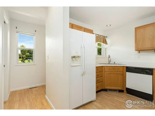 a kitchen with stainless steel appliances a refrigerator sink and white cabinets