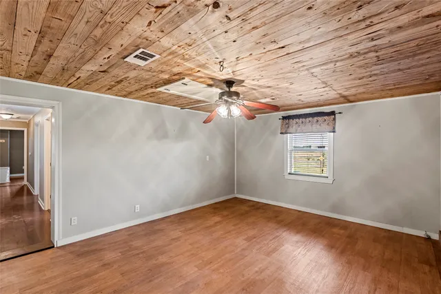 en empty room with windows and chandelier fan