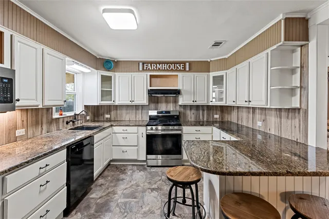a kitchen with stainless steel appliances granite countertop a stove and more cabinets