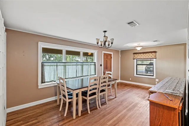 a view of a dining room with furniture wooden floor and chandelier