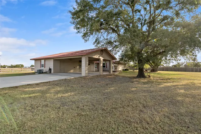 a view of a house with backyard and trees