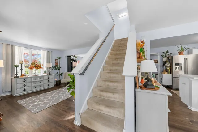 a bedroom with a bed a desk and chair with the wooden floor