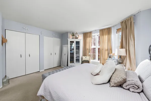 a spacious bedroom with a bed and a large window