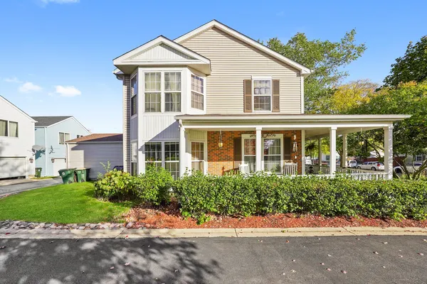 a front view of a house with a yard and potted plants
