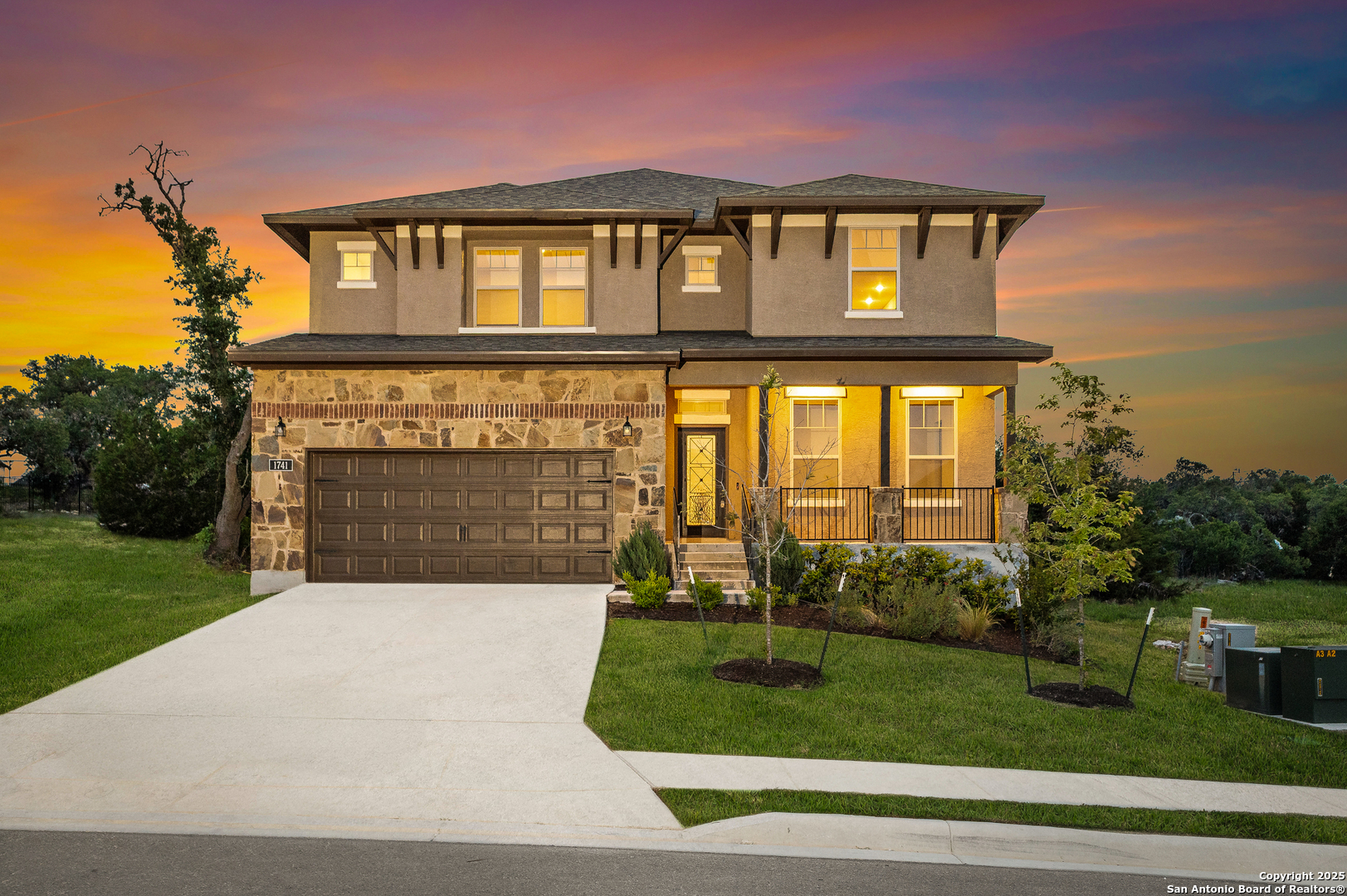 a front view of a house with a yard and potted plants