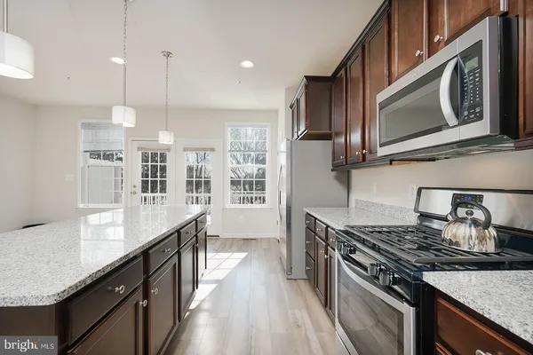 a kitchen with stainless steel appliances granite countertop a stove a sink and a microwave