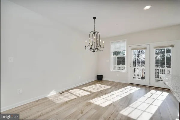 a view of a livingroom with wooden floor and windows