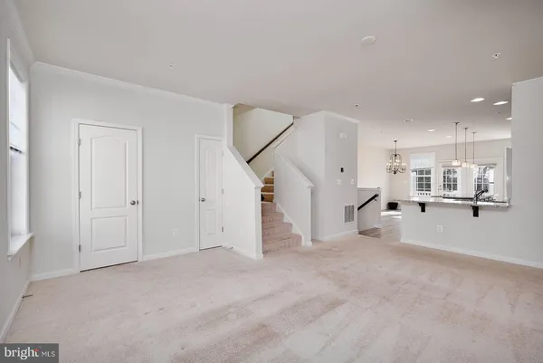 a view of a livingroom with wooden floor and staircase