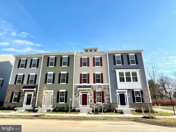 a front view of a building with lot of cars and trees