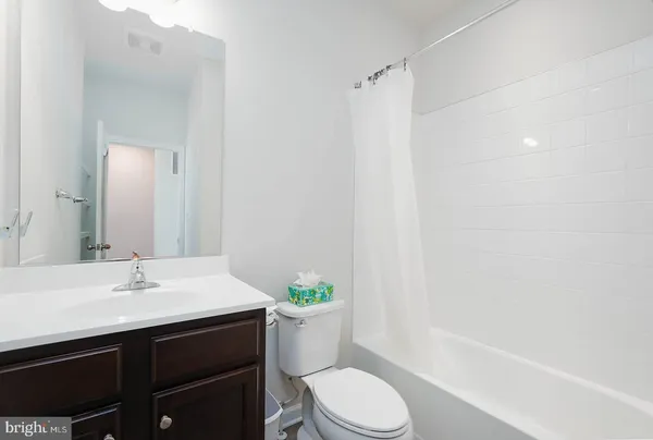 a bathroom with a sink a toilet a mirror and shower