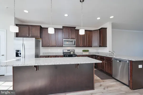 a kitchen with stainless steel appliances granite countertop a sink a stove and a refrigerator