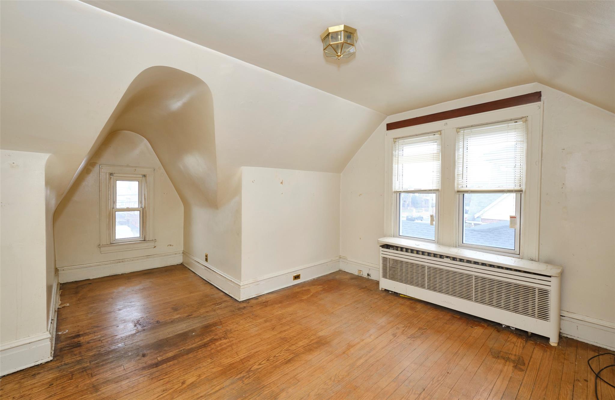135-47 229th Street Queens, NY 11413 - Photo 19 of 36 Bonus room featuring radiator, hardwood / wood-style flooring, and vaulted ceiling