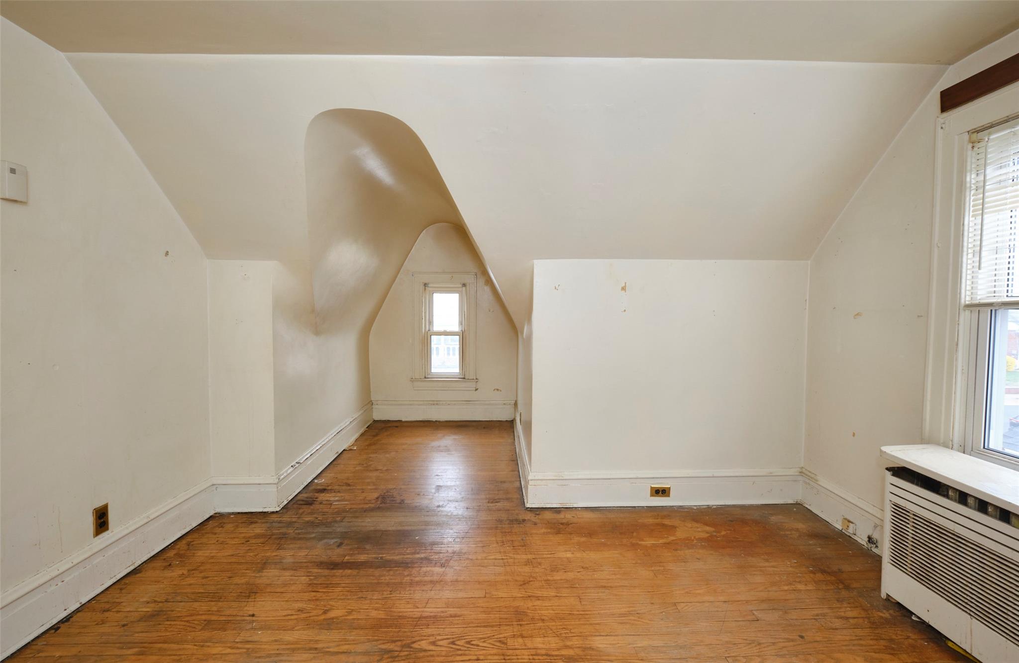 135-47 229th Street Queens, NY 11413 - Photo 20 of 36 Additional living space featuring hardwood / wood-style floors, radiator, baseboards, and vaulted ceiling