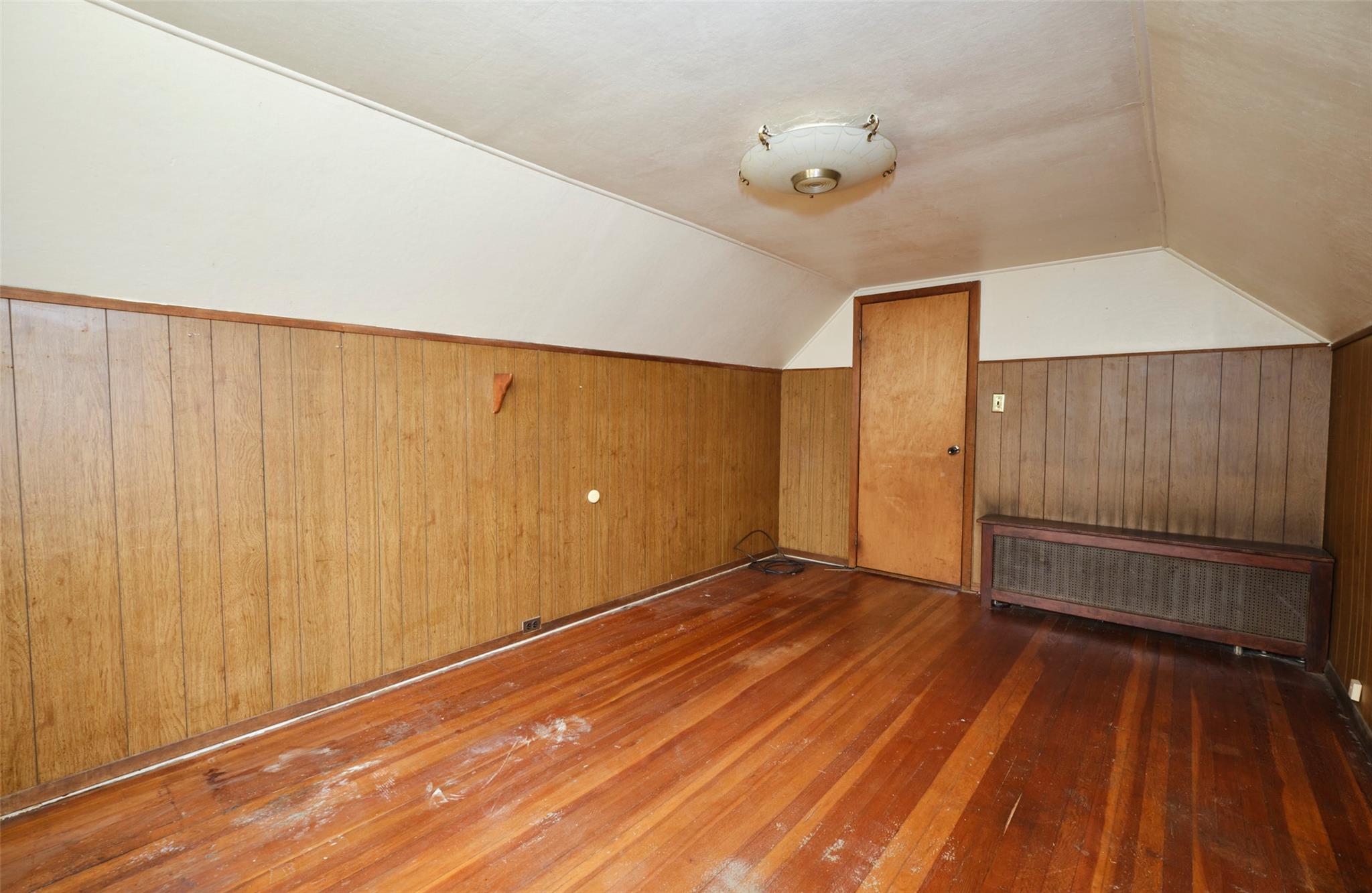 135-47 229th Street Queens, NY 11413 - Photo 24 of 36 Bonus room with hardwood / wood-style flooring, wood walls, radiator heating unit, and lofted ceiling