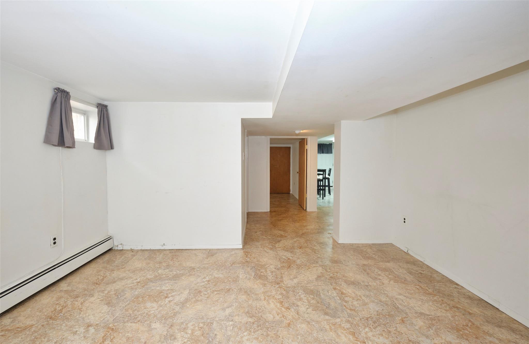135-47 229th Street Queens, NY 11413 - Photo 27 of 36 Spare room with a baseboard heating unit