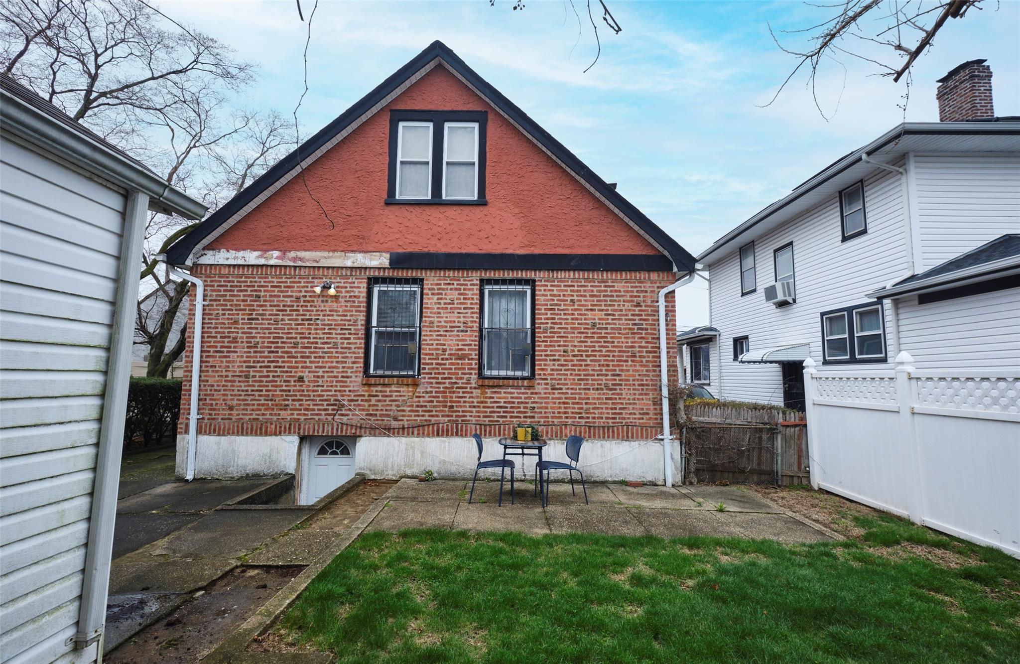 135-47 229th Street Queens, NY 11413 - Photo 33 of 36 Back of house, brick siding, fence, and a lawn